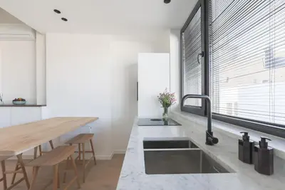 a kitchen with a sink and a large window at Southside Suites in Antwerp
