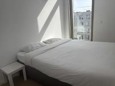 a white bed in a room with a window at Splendid Penthouse in City Center with Water View in Brussels