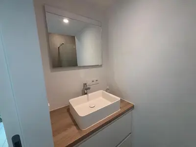 a bathroom with a white sink and a mirror at Splendid Penthouse in City Center with Water View in Brussels