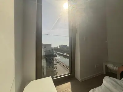 a bedroom with a window with a view of a city at Splendid Penthouse in City Center with Water View in Brussels