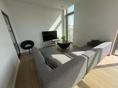 a living room with a couch and a tv at Splendid Penthouse in City Center with Water View in Brussels