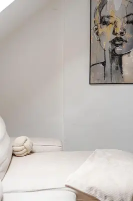 a white couch in a living room with a painting at Elegant Stay in Châtelain Ixelles in Brussels