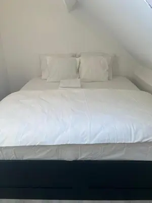 a large bed with white sheets and pillows at Only For Tomorrowland in Boom