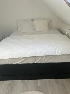 a large bed with white sheets and pillows on it at Only For Tomorrowland in Boom