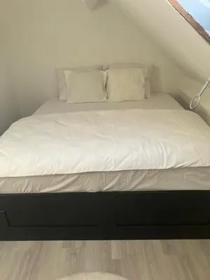 a bed with white sheets and pillows in a room at Only For Tomorrowland in Boom
