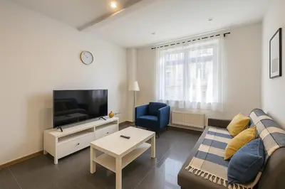 a living room with a couch and a tv at Cosy studio Midi station in Brussels