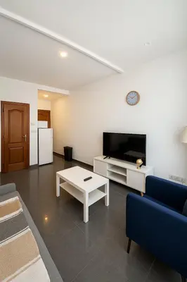 a living room with a couch and a tv and a table at Cosy studio Midi station in Brussels