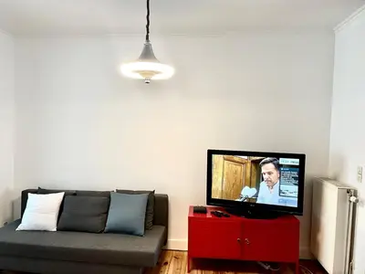 a living room with a couch and a flat screen tv at Le Flagey green place in Brussels