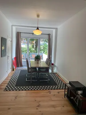 a dining room with a table and chairs and a window at Le Flagey green place in Brussels