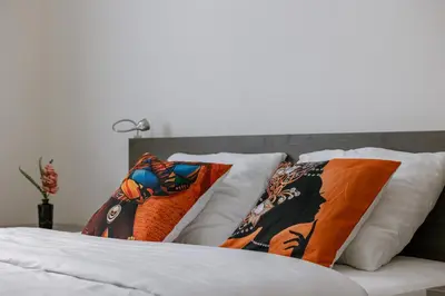 a pile of pillows on a bed in a bedroom at Bruxelles Cozy Atomium Expo in Brussels