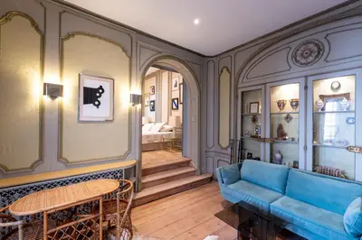 a living room with a blue couch and a table at Les Appartements du Sablon in Brussels