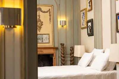 a bedroom with a bed with white pillows and a fireplace at Les Appartements du Sablon in Brussels