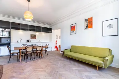 a living room with a green couch and a table at Les Appartements du Sablon in Brussels