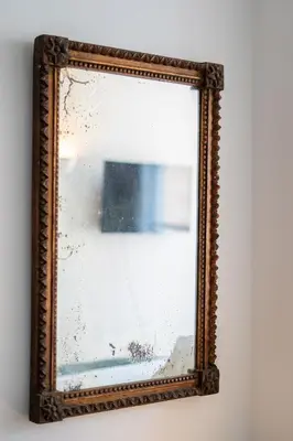 a mirror with a picture in a wooden frame on a wall at Les Appartements du Sablon in Brussels