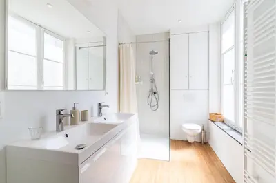 a white bathroom with a sink and a toilet at Les Appartements du Sablon in Brussels