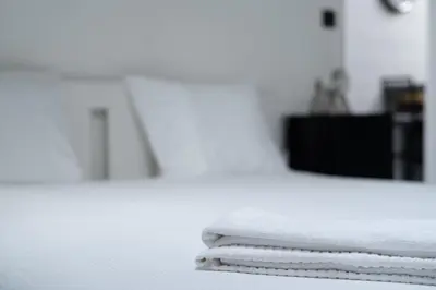 a stack of white towels sitting on top of a bed at Cocon douillet à Bruxelles in Brussels