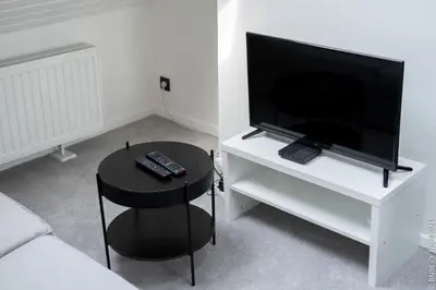 a living room with a tv and a table with a stool at Cocon douillet à Bruxelles in Brussels