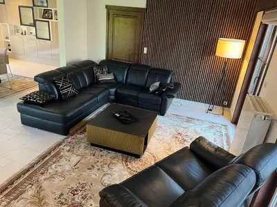 a living room with a leather couch and a coffee table at Luxe Villa Lou & Hans in Aalst