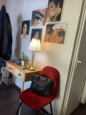 a desk with a red chair and pictures on the wall at Cosy appartment near city center in Brussels