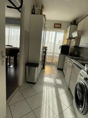 a kitchen with a washer and dryer on a tile floor at Cosy appartment near city center in Brussels