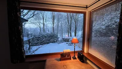 a window with a view of a snow covered yard at PepperLake in Overijse