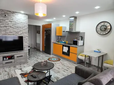 a living room with a couch and a tv and a kitchen at New build flat - Walking distance from Brussels Airport in Zaventem