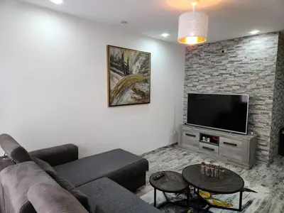 a living room with a couch and a flat screen tv at New build flat - Walking distance from Brussels Airport in Zaventem