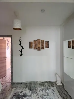 a room with a white wall with paintings on it at New build flat - Walking distance from Brussels Airport in Zaventem