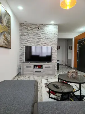 a living room with a flat screen tv on a brick wall at New build flat - Walking distance from Brussels Airport in Zaventem