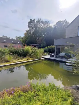 a house with a pond in the yard at Naturedegrez in Grez-Doiceau