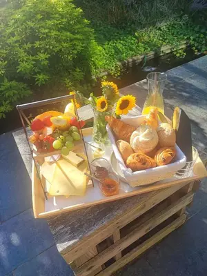 a picnic table with a tray of food and flowers at Naturedegrez in Grez-Doiceau