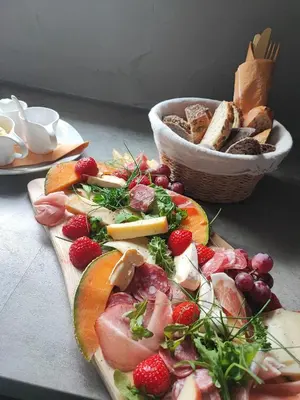 a plate of food with fruit and a basket of bread at Naturedegrez in Grez-Doiceau