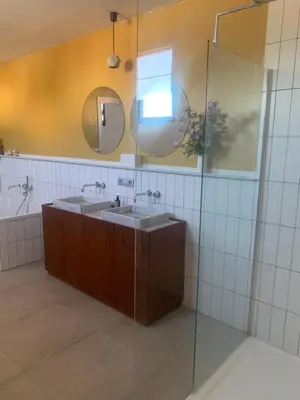 a bathroom with two sinks and a glass shower at Heritage Mansion near Tomorrowland in Niel