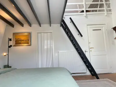 a bedroom with a bed and a stair case at Charming Family Townhouse in Antwerp in Antwerp