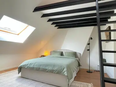 a bedroom with a bed in a room with skylights at Charming Family Townhouse in Antwerp in Antwerp