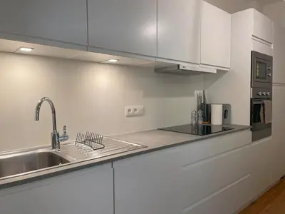 a kitchen with white cabinets and a sink at Charming Family Townhouse in Antwerp in Antwerp