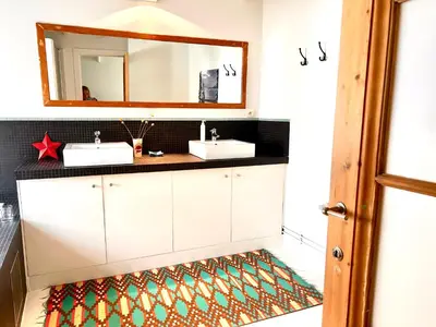 a bathroom with two sinks and a mirror at Heart of Antwerp House in Antwerp