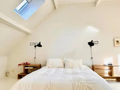 a white bedroom with a bed and two lamps at Heart of Antwerp House in Antwerp