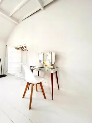 a white chair sitting next to a table with a microwave at Heart of Antwerp House in Antwerp