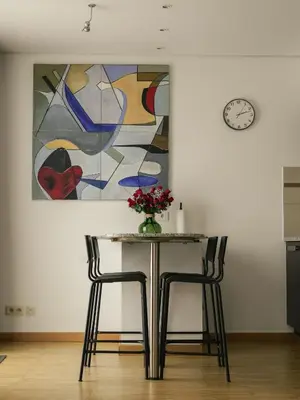 a table with two chairs and a painting on the wall at Elios Living Studio Mettewie in Brussels