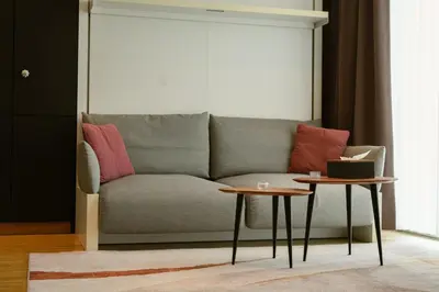 a living room with a couch and two tables at Elios Living Studio Mettewie in Brussels