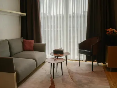 a living room with a couch and a table and a piano at Elios Living Studio Mettewie in Brussels