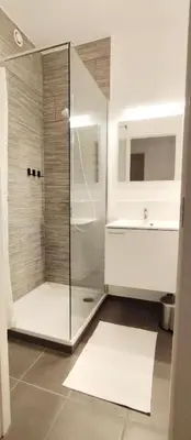 a bathroom with a glass shower and a sink at Sleep & Explore Brussels in Brussels