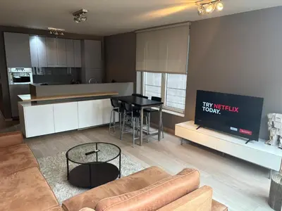 a living room with a couch and a table in a kitchen at Sleep & Explore Brussels in Brussels