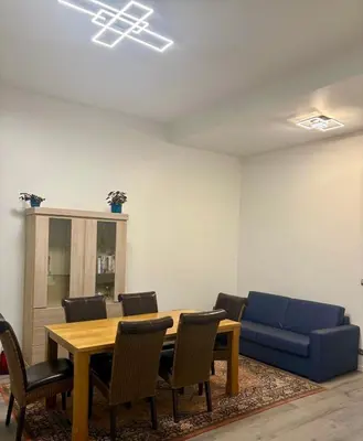 a room with a table and chairs and a blue couch at Modern 1 bedroom and sofa bed stay in Brussels
