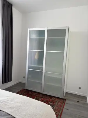 a large glass cabinet in a room with a bed at Modern 1 bedroom and sofa bed stay in Brussels