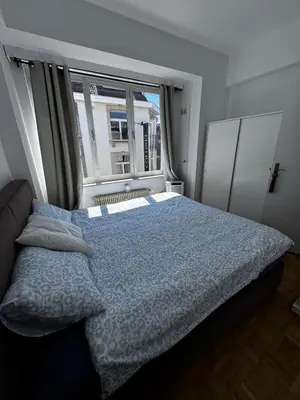 a bedroom with a bed and a large window at Place Stéphanie - Avenue Louise - Bruxelles Centre in Brussels