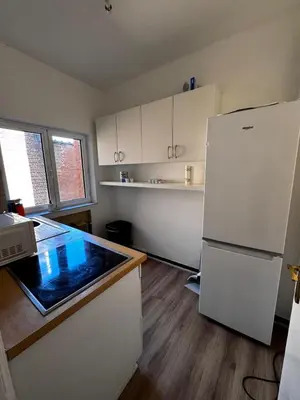 a kitchen with a white refrigerator and wooden floors at Place Stéphanie - Avenue Louise - Bruxelles Centre in Brussels