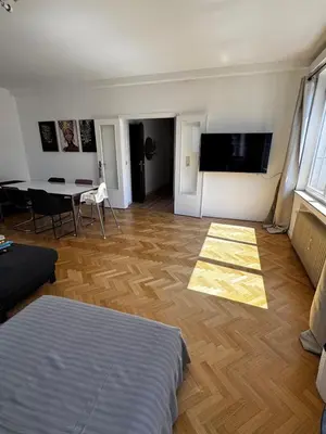 a living room with a bed and a table and a television at Place Stéphanie - Avenue Louise - Bruxelles Centre in Brussels
