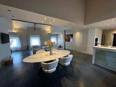 a large living room with a table and chairs at Luxe Duplex te Koningshooikt in Koningshooikt